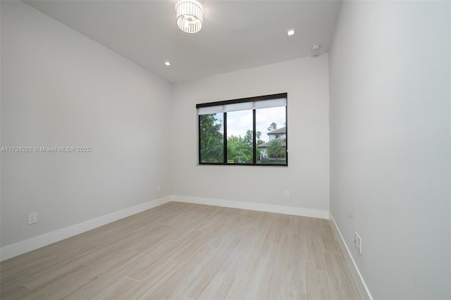 empty room featuring light wood-style floors, baseboards, and recessed lighting