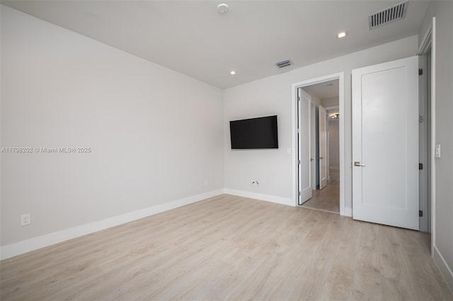unfurnished room with light wood finished floors, visible vents, baseboards, and recessed lighting