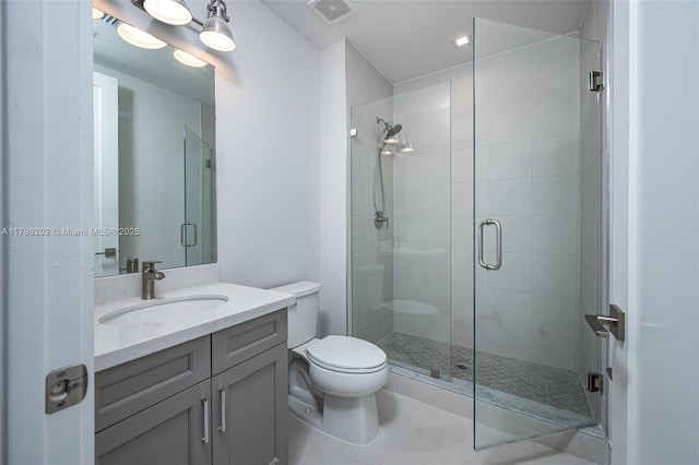 full bathroom featuring vanity, toilet, visible vents, and a shower stall