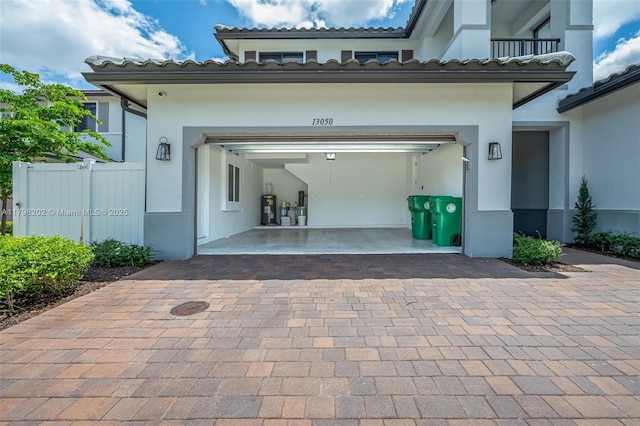 garage with fence and decorative driveway