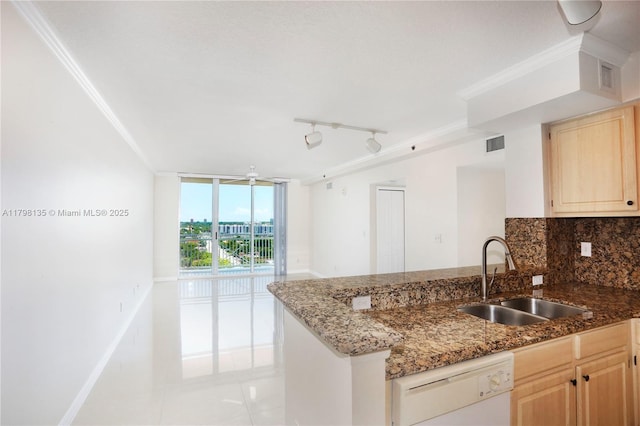 kitchen with light brown cabinetry, dishwasher, light tile patterned floors, visible vents, and a sink