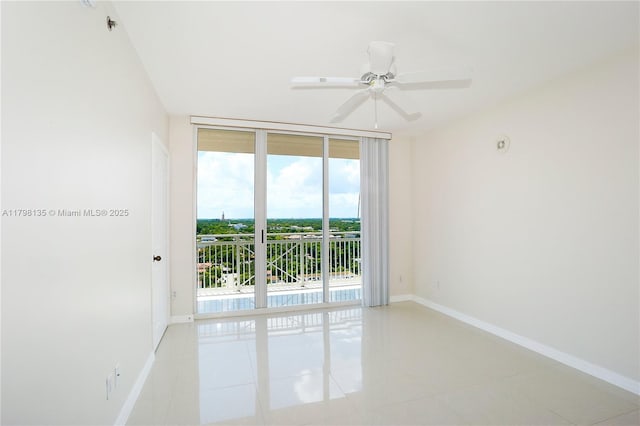 empty room with light tile patterned floors, baseboards, and a ceiling fan