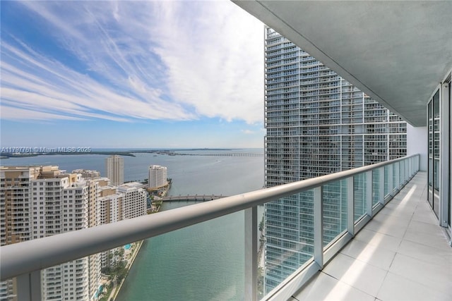 balcony with a water view and a view of city
