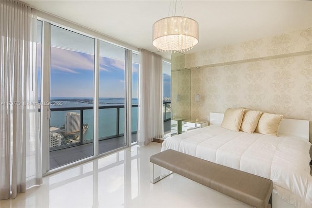 bedroom featuring floor to ceiling windows, a water view, multiple windows, a chandelier, and access to outside