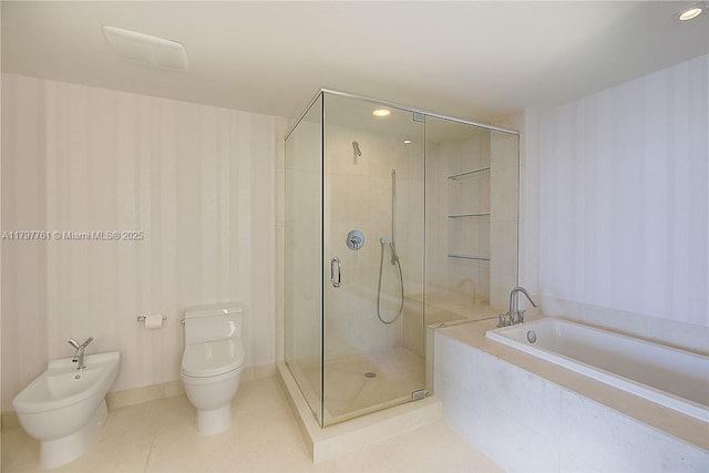 bathroom featuring a shower stall, a garden tub, a bidet, toilet, and wallpapered walls