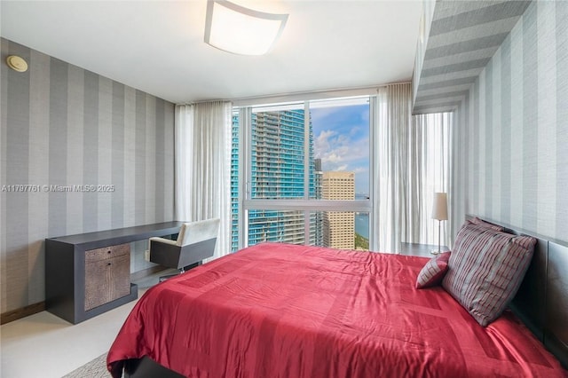 bedroom with wallpapered walls and a view of city