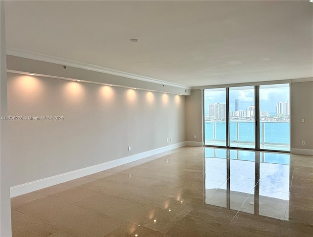 unfurnished room with a city view, crown molding, expansive windows, and baseboards