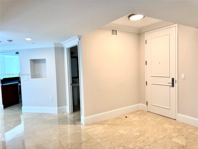 empty room with crown molding, baseboards, and marble finish floor