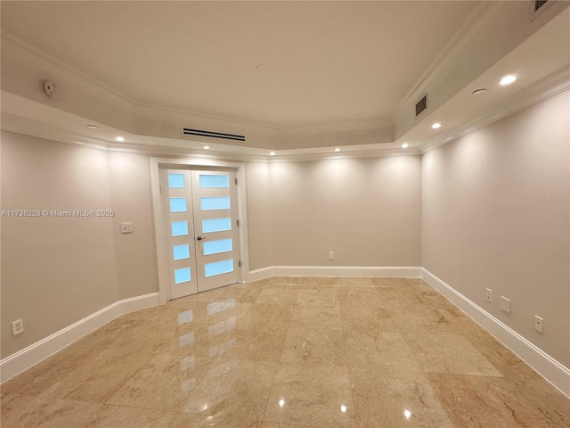 spare room featuring a tray ceiling, crown molding, baseboards, and french doors