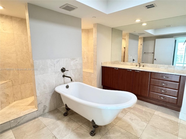 full bath with a soaking tub, tile walls, visible vents, vanity, and recessed lighting
