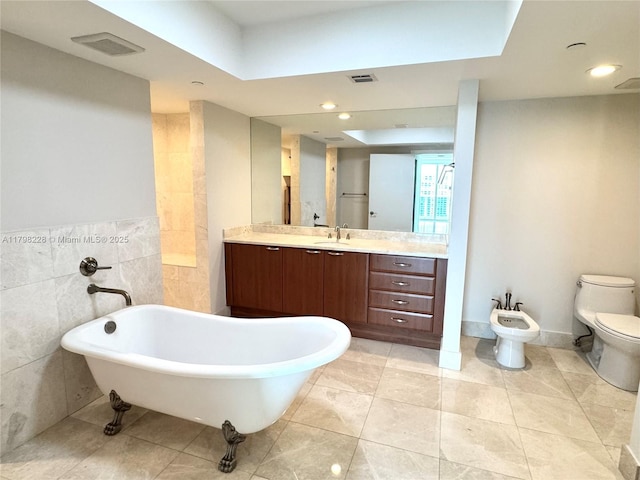 full bathroom featuring vanity, a soaking tub, visible vents, and a bidet