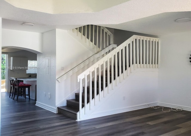 6101 NW 114th Ct Unit 124, Doral, FL 33178 - stairs featuring wood finished floors, baseboards, and arched walkways