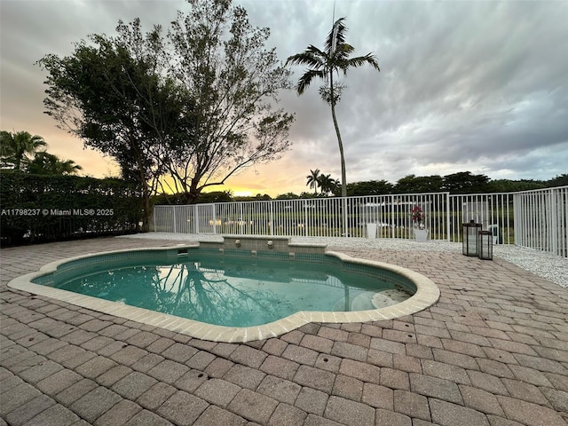 1048 SE Sunflower Cir, Weston, FL 33327 - pool at dusk featuring a patio area, a fenced in pool, and fence