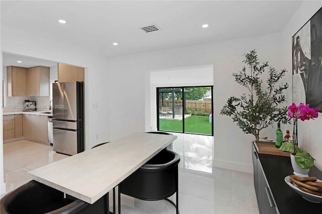 231 NE 45th St, Miami, FL 33137 - kitchen featuring freestanding refrigerator, light countertops, light tile patterned floors, and modern cabinets