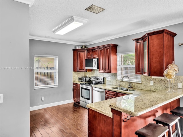 10273 SW 16th Ct, Pembroke Pines, FL 33025 - kitchen with a sink, dark brown cabinets, appliances with stainless steel finishes, dark wood-style floors, and decorative backsplash