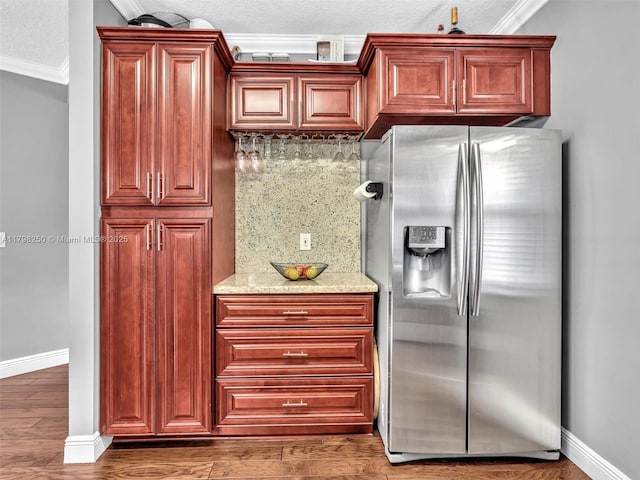 10273 SW 16th Ct, Pembroke Pines, FL 33025 - kitchen featuring stainless steel fridge with ice dispenser, crown molding, baseboards, decorative backsplash, and light stone counters