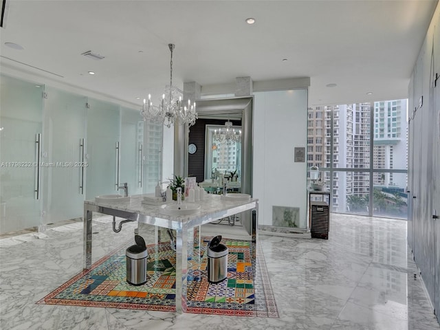 dining space featuring a chandelier, marble tiled floors, and expansive windows
