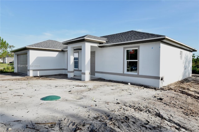 4463 60th Ave NE, Naples, FL 34120 - rear view of property featuring a shingled roof, an attached garage, and stucco siding