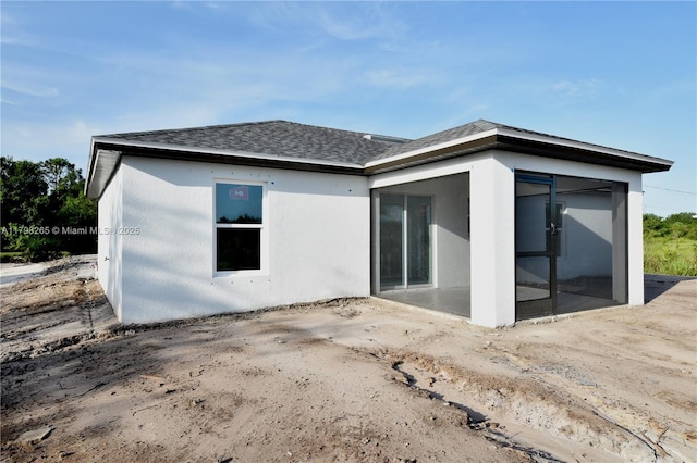4463 60th Ave NE, Naples, FL 34120 - back of house featuring roof with shingles, a patio area, a sunroom, and stucco siding
