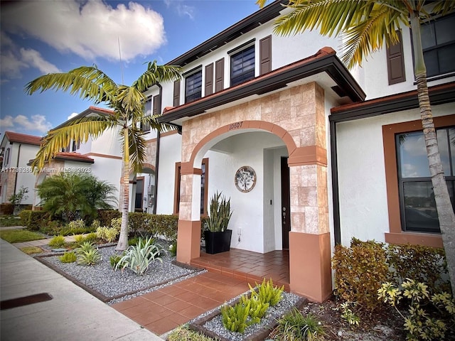 entrance to property with stone siding and stucco siding