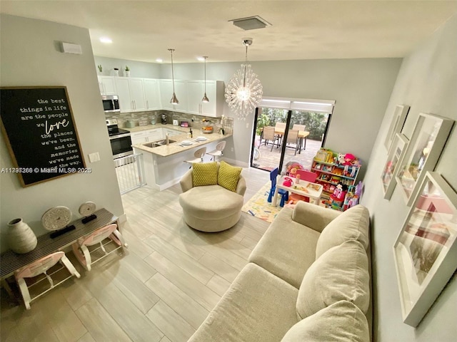 living area featuring light wood-type flooring, a chandelier, recessed lighting, and lofted ceiling