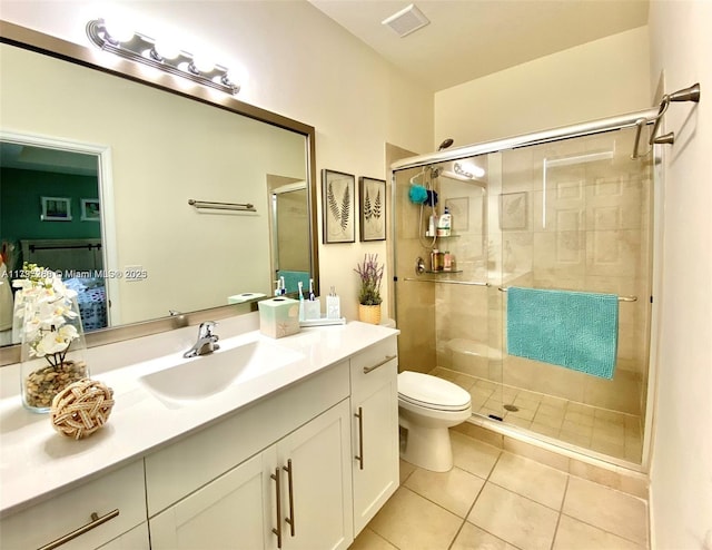 bathroom with tile patterned flooring, a shower stall, toilet, and vanity