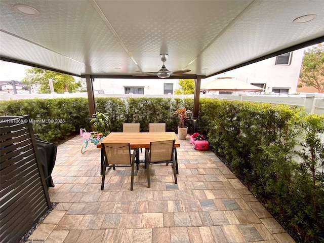 view of patio with outdoor dining space, a fenced backyard, and ceiling fan