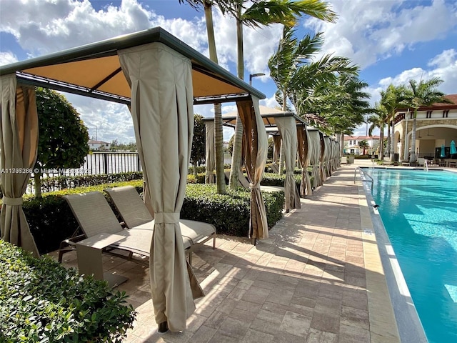community pool with a patio area, fence, and a gazebo