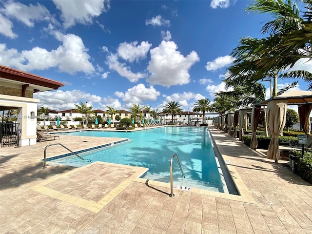 community pool with a gazebo and a patio