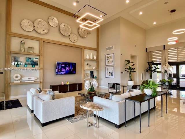 living room featuring a towering ceiling, built in features, light tile patterned floors, a chandelier, and recessed lighting