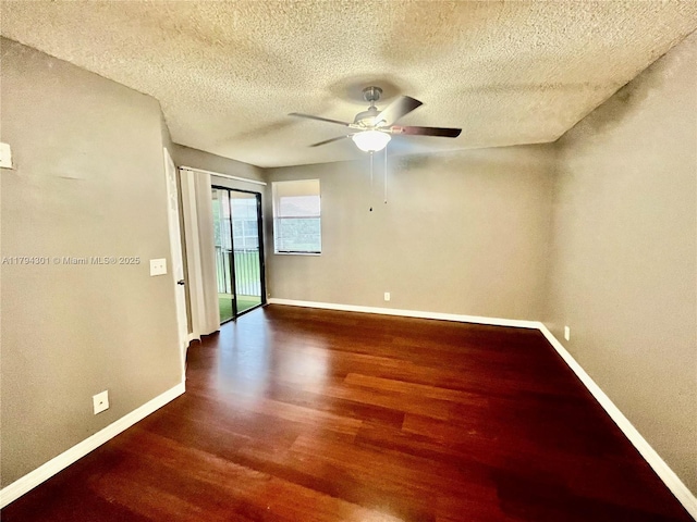 empty room featuring wood finished floors, baseboards, a ceiling fan, and a textured ceiling
