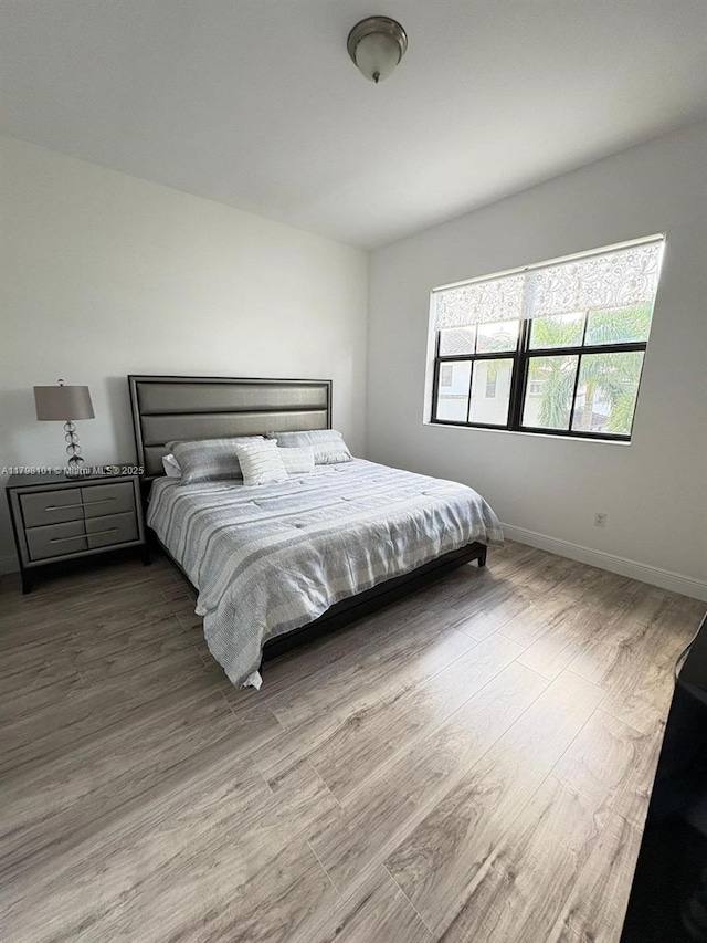 bedroom featuring wood finished floors and baseboards