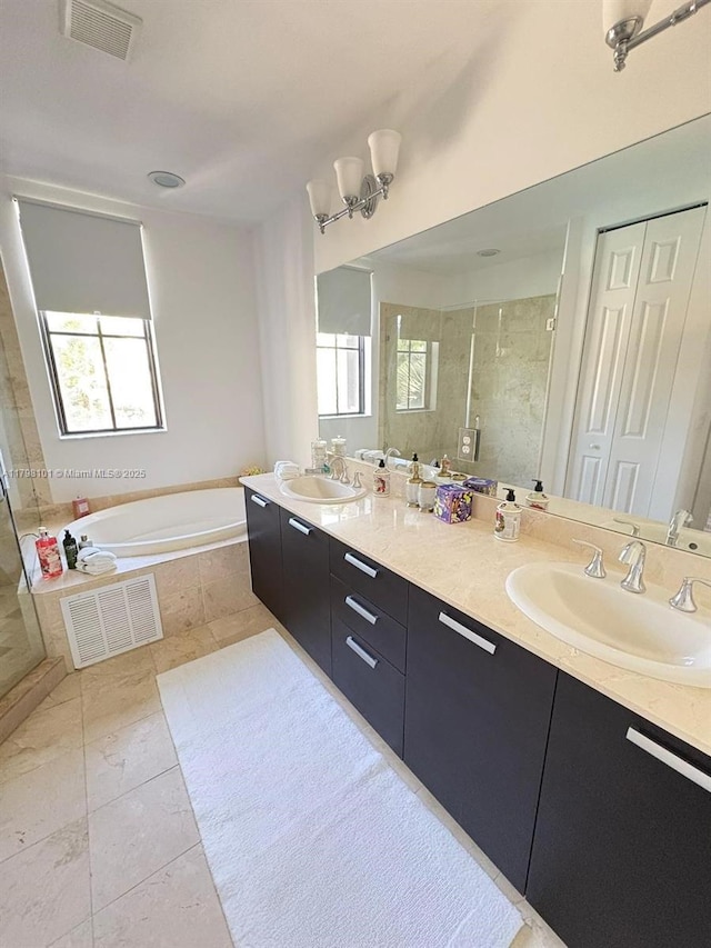 bathroom featuring a garden tub, a stall shower, and double vanity