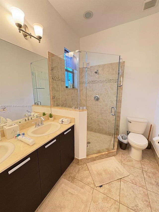full bath featuring a shower stall, toilet, double vanity, and tile patterned flooring