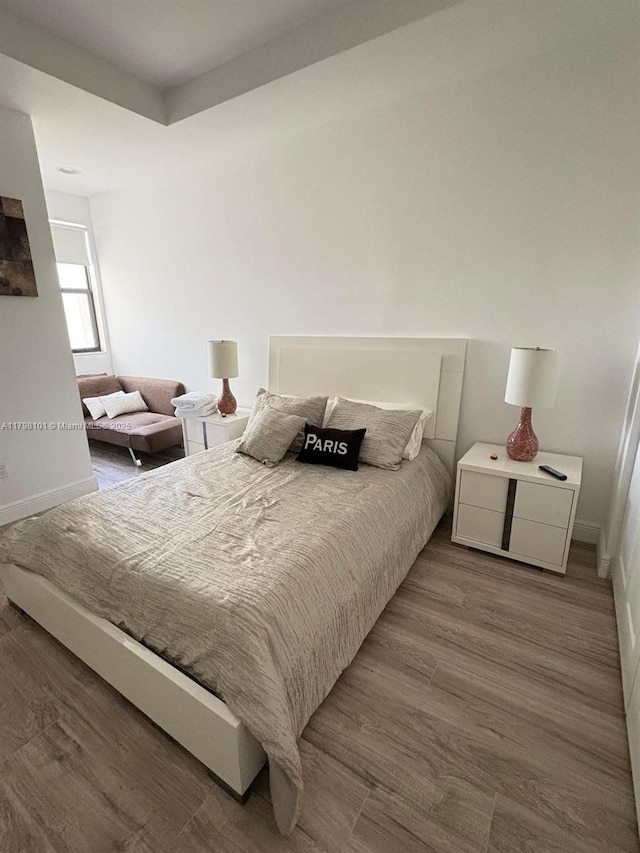 bedroom featuring wood finished floors and baseboards