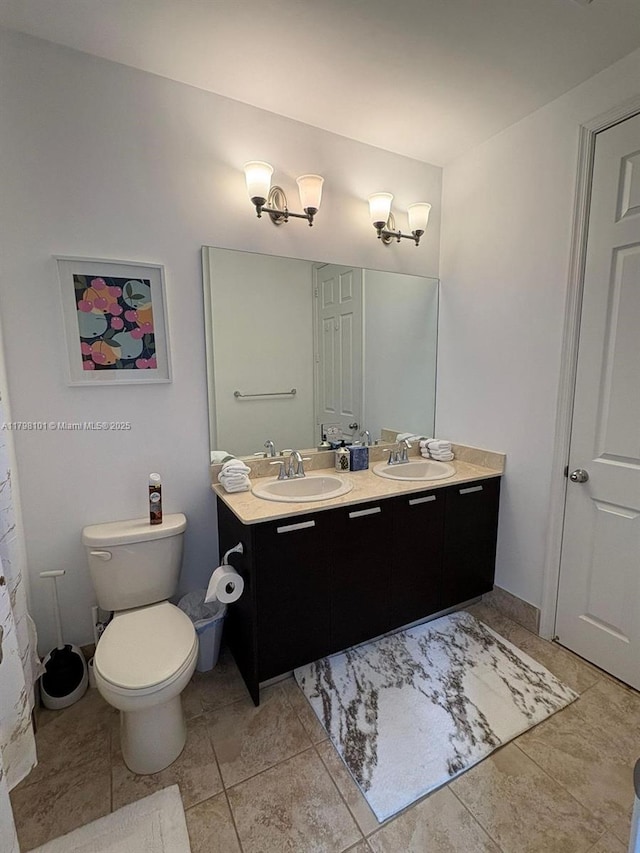 bathroom with double vanity, toilet, and tile patterned flooring