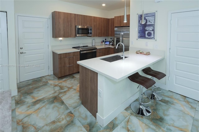 4962 NW 83rd Path Unit 4962, Doral, FL 33166 - kitchen with appliances with stainless steel finishes, modern cabinets, a sink, brown cabinetry, and a kitchen bar