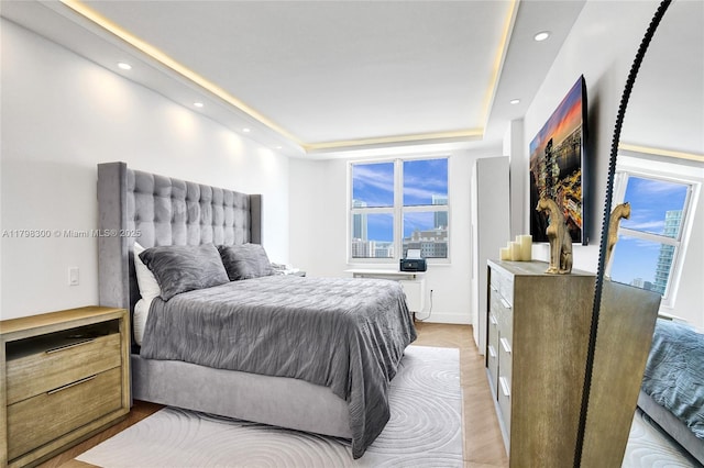 1980 S Ocean Dr Unit 19H, Hallandale Beach, FL 33009 - bedroom featuring recessed lighting, multiple windows, light wood-style floors, a tray ceiling, and baseboards