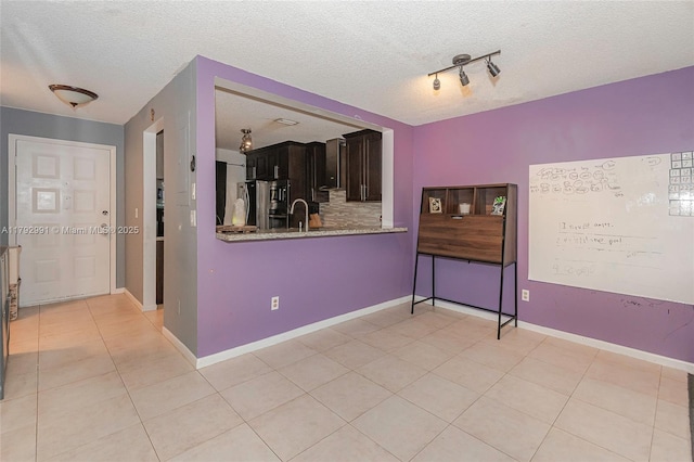 11733 NW 11th St, Pembroke Pines, FL 33026 - empty room featuring a textured ceiling, a sink, light tile patterned floors, baseboards, and track lighting