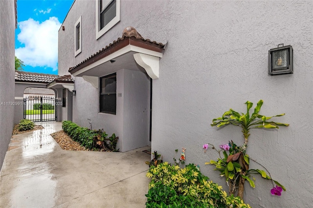 11733 NW 11th St, Pembroke Pines, FL 33026 - view of side of property featuring a gate, a tiled roof, stucco siding, and a patio