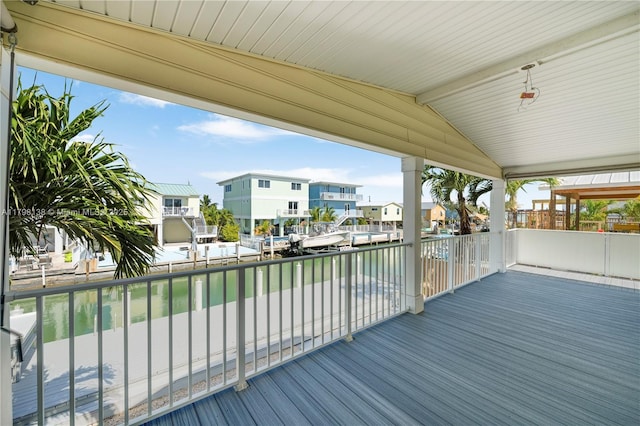 wooden deck with a residential view and a water view