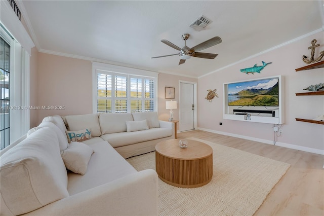 living area with wood finished floors, ceiling fan, ornamental molding, baseboards, and vaulted ceiling