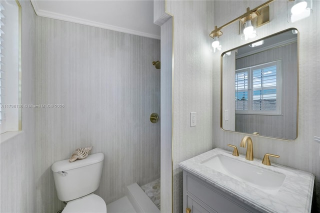 bathroom with toilet, a tile shower, and vanity