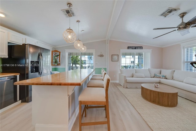 kitchen with appliances with stainless steel finishes, light wood finished floors, and healthy amount of natural light
