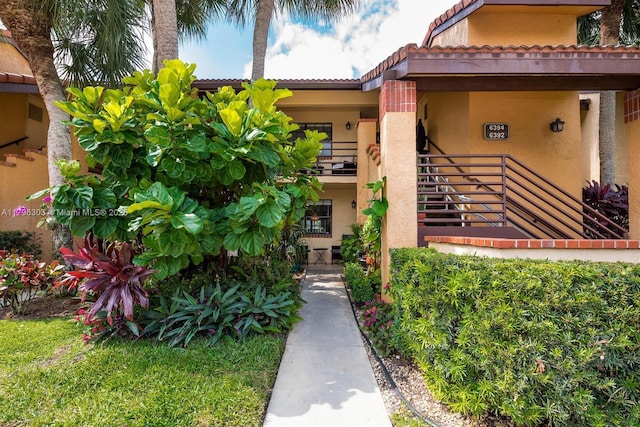 6392 Aspen Glen Cir Unit 1, Boynton Beach, FL 33437 - view of exterior entry featuring stucco siding and a tiled roof