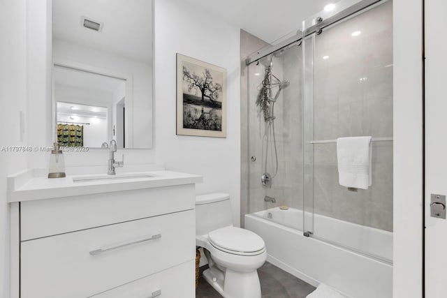 full bath featuring toilet, vanity, and shower / bath combination with glass door