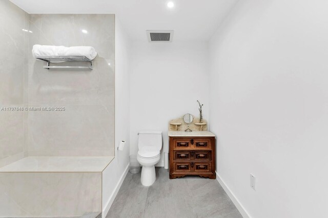bathroom with baseboards, toilet, recessed lighting, and a shower