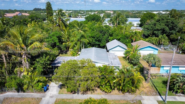 bird's eye view of a tree filled landscape and a pool