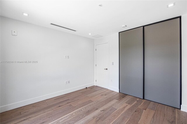 204 Sunrise Dr Unit 204D, Key Biscayne, FL 33149 - unfurnished bedroom featuring wood finished floors, baseboards, and a closet