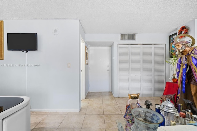 17021 N Bay Rd Unit 727, Sunny Isles Beach, FL 33160 - interior space featuring a closet, light tile patterned flooring, a textured ceiling, and baseboards
